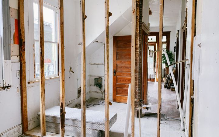 Room under renovation with the wall opened down to the wood studs